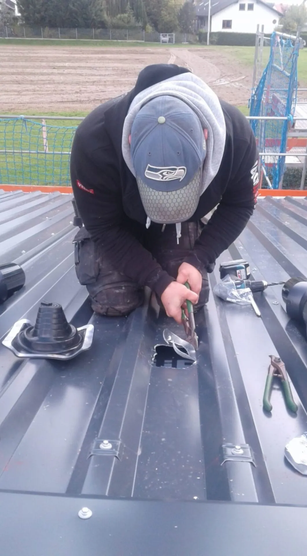 Dachdecker von Gehrlicher bei Falzarbeiten auf dem Dach